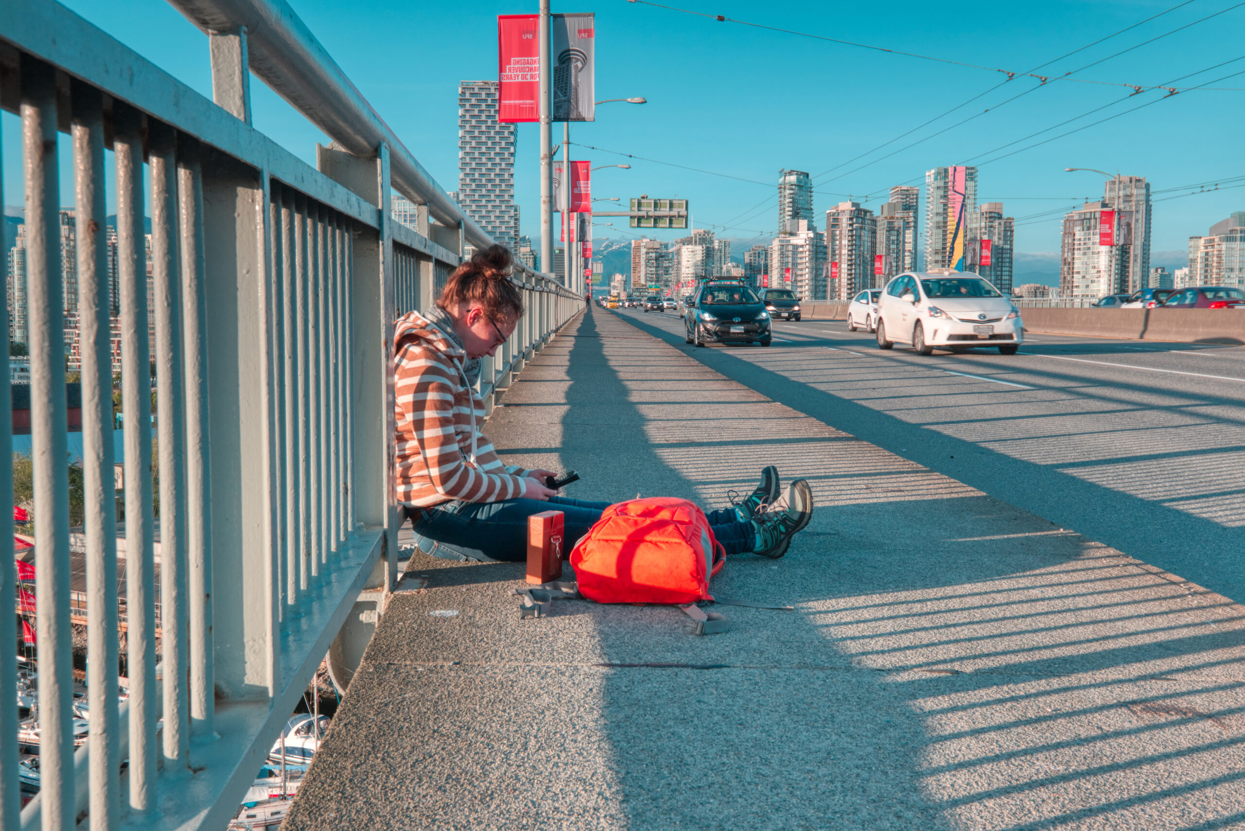 Downtown Vancouver Canada. Scenic view at Grandville Bridge ayoung woman is sitting on the bridge, Vancouver, Canada